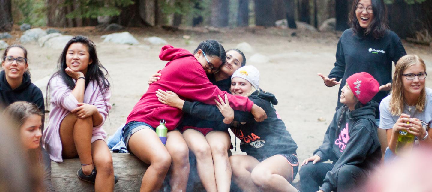 Students hug around a campfire in Yosemite