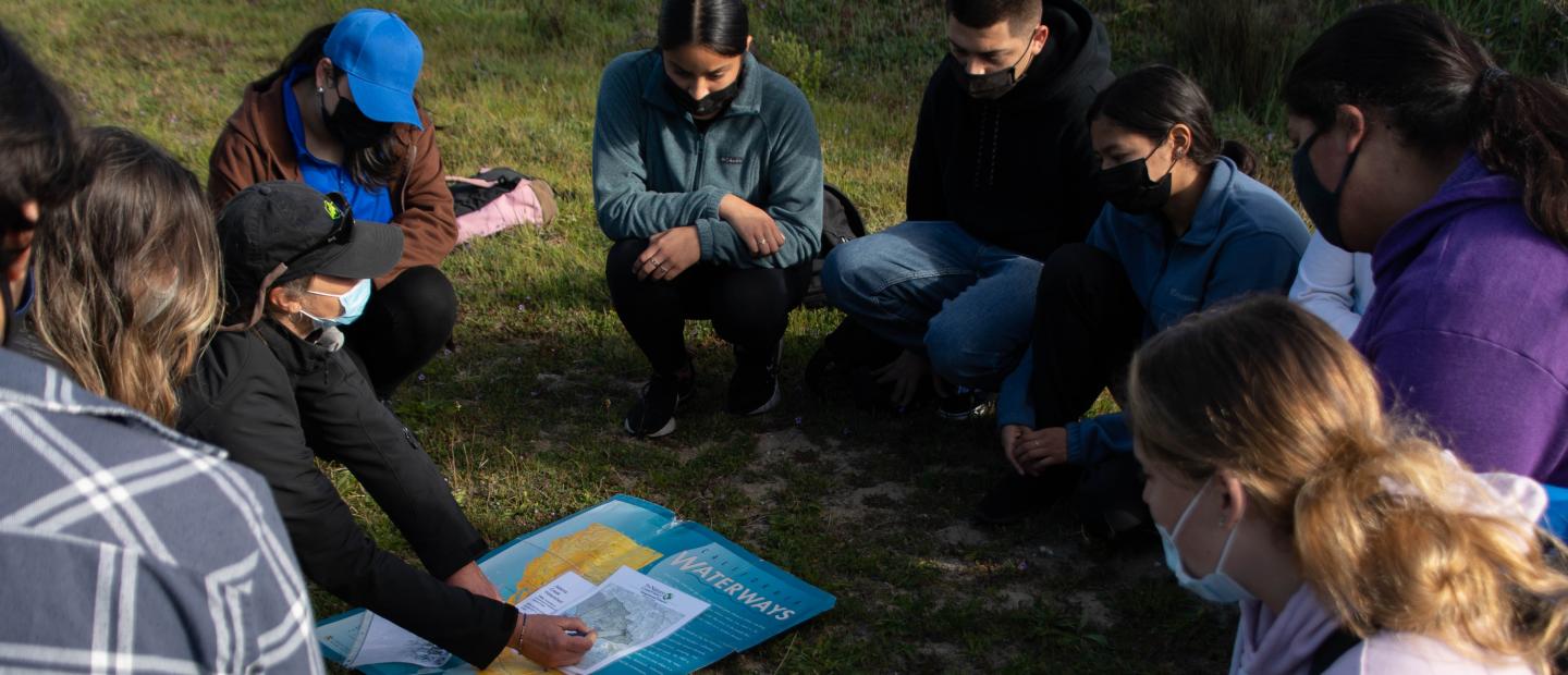 Students examining a map of waterways in the Dangermond Preserve